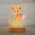 Acrylic giraffe night light on a wooden base